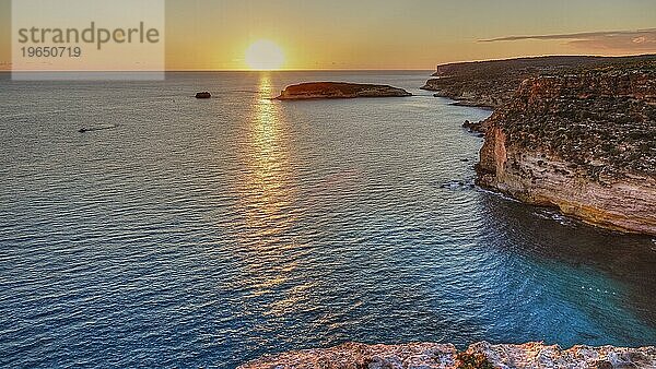 Sonnenuntergang  Sonnenstrahl auf dem Meer  Gegenlicht  Wolken  Steilküste  Isola dei Conigli  Spiaggia dei Conigli  Riserva Naturale Orientata Isola di Lampedusa  Insel Lampedusa  Provinz Agrigento  Pelagische Inseln  Sizilien  Italien  Europa