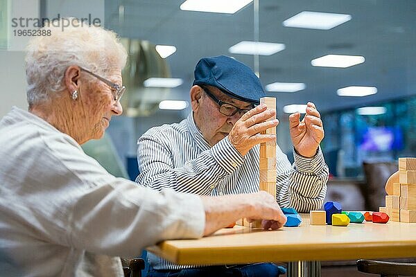 Ein Paar älterer Menschen in einem Pflegeheim spielt Geschicklichkeitsspiele