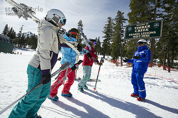 Eine Gruppe von Frauen versammelt sich im Winter im Kirkwood Mountain Resort in Kirkwood  Kalifornien  und hört ihrem Skilehrer zu.