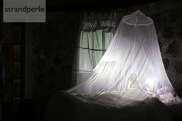 Ein junger Mann schläft in einem Moskitonetz in einer Öko-Lodge in Äthiopien.