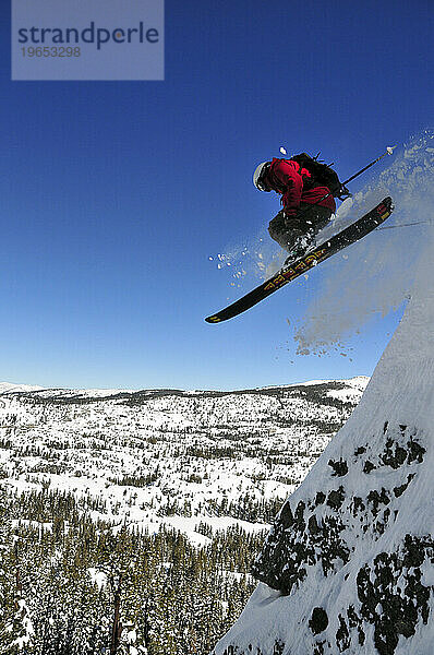 Ein Mann fährt Ski von einer großen Klippe im Hinterland von Kirkwood in der Nähe von South Lake Tahoe  Kalifornien.