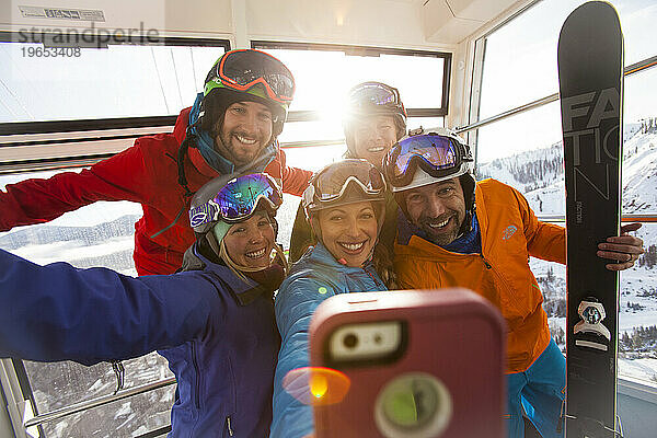 Eine Gruppe von Freunden macht ein Selfie in einer Gondel in einem Skigebiet.