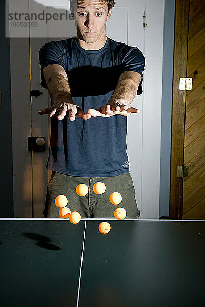 Ein Mann gibt vor  zu zeigen  dass er 8 Tischtennisbälle auf einmal schweben lassen kann.