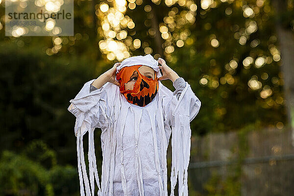 Kleiner Junge trägt eine Kürbis-  Mama- und Geister-Halloween-Mischung.