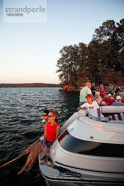 Eine Gemeinschaft von Menschen  die alle an einem See leben  binden an einem sonnigen Abend ihre Boote für eine Party zusammen.