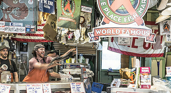 Ein Arbeiter wirft einen Fisch auf dem Pike Place Market in der Innenstadt von Seattle  Washington