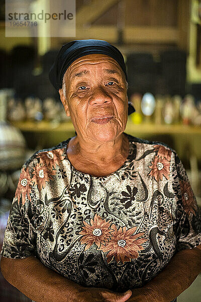 Ein Porträt einer Kalinago-Frau in ihrem Korbladen im Touna Kalinago Heritage Village im Kalinago-Territorium auf der Karibikinsel Dominica.