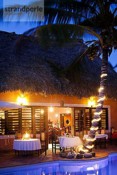 Ein Restaurant wird in der Nähe eines Pools in einem Luxushotel in Belize beleuchtet.