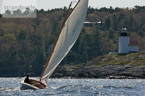 Ein Mann segelt vor der Küste von Maine