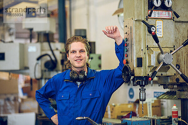 Professioneller Arbeiter steht in der Nähe der Bohrmaschine