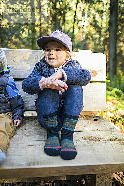 Junges Mädchen sitzt auf Bank und trägt gemütliche Socken