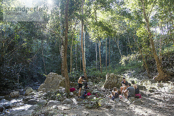 Eine Gruppe junger Wanderer genießt während einer Wanderung in der Nähe der Stadt Pai in Thailand eine Pause im Wald.