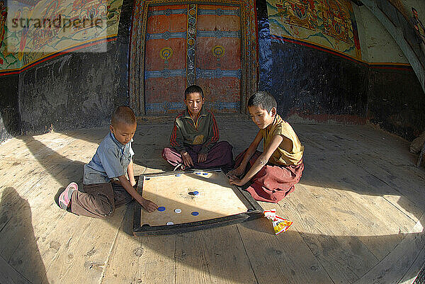 Drei Kinder spielen Karambolage in Nepal.1 S