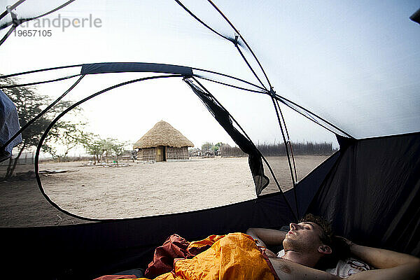 Ein junger Mann schläft in einem Zelt in der Nähe des Dorfes Karo im Süden Äthiopiens.