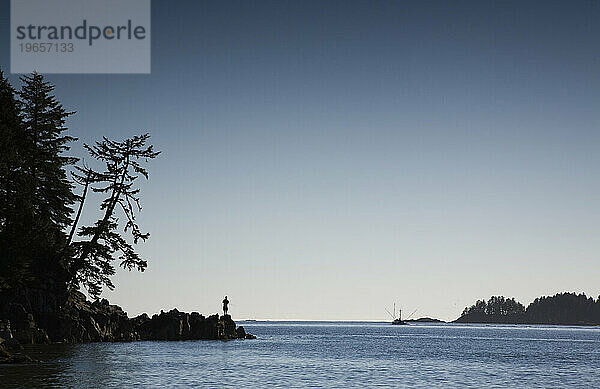 Die Silhouette eines Mannes vor blauem Himmel fischt vor der Küste von Vancouver Island.