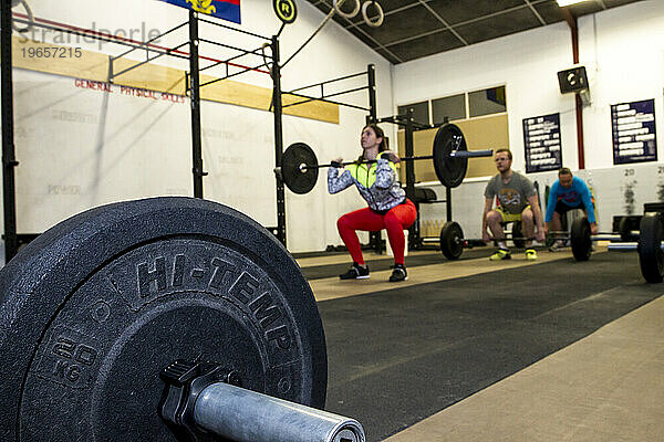 Mädchen beim Gewichtheben während eines Crossfit-Kurses