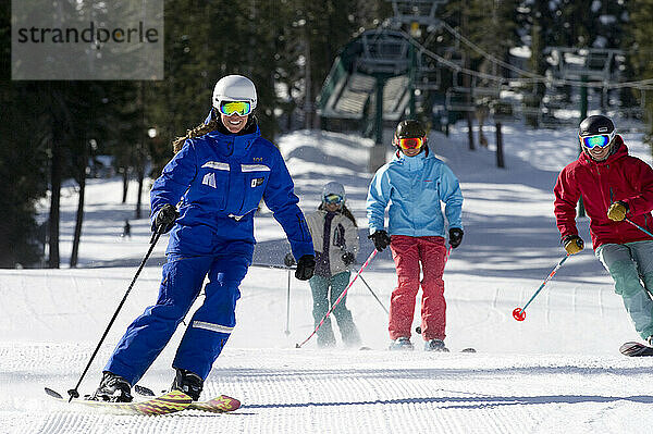 Eine Gruppe Skifahrerinnen folgt ihrem Skilehrer im Winter eine präparierte Piste im Kirkwood Mountain Resort in Kirkwood  Kalifornien.