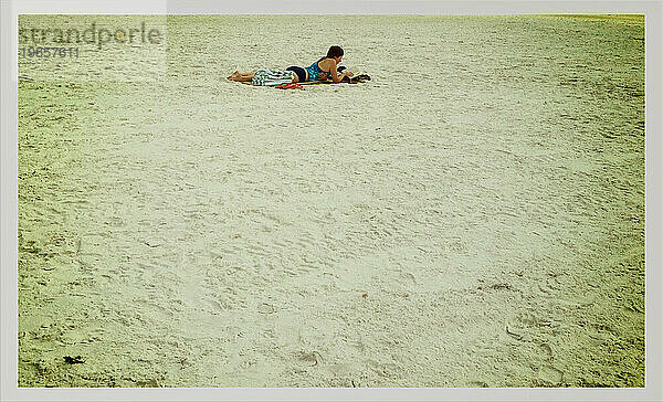 Frau liest am einsamen Strand