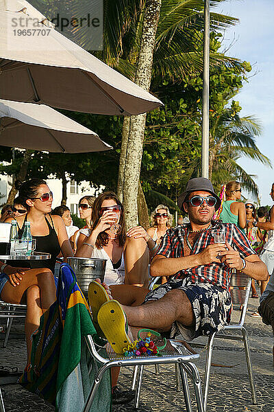 Menschen sitzen in einem Café an der Strandpromenade von Arpoador  Rio de Janeiro  Brasilien.