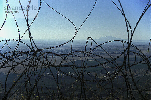 Blick durch Stacheldraht in den Libanon  von den von Israel kontrollierten Golanhöhen  Israel.