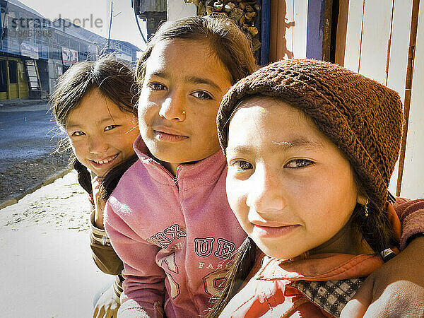 Drei junge nepalesische Mädchen schauen in Nepal in die Kamera.