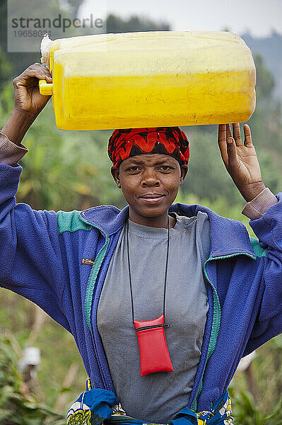 Frau mit Wasserkrug auf dem Kopf in Ruanda