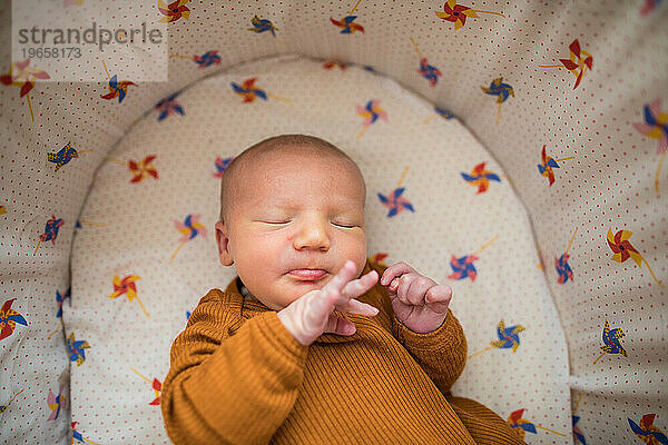 Neugeborenes Baby streckt seine kleinen Finger aus  während es im Bett schläft
