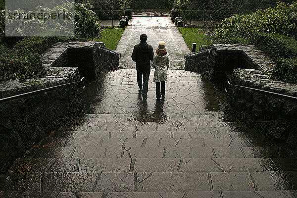 Ein Paar geht in Portland  Oregon  eine nasse Treppe hinunter.