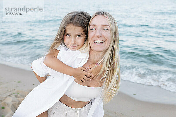 Mother's love for daughter. Mother and daughter play near the sea