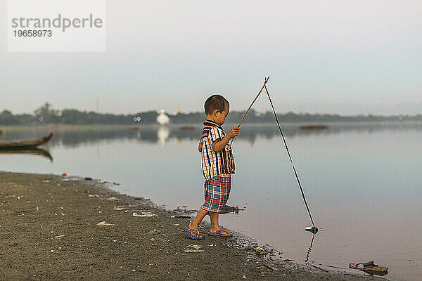 Junge spielt mit Angelrute  Mandalay  Mandalay District  Myanmar