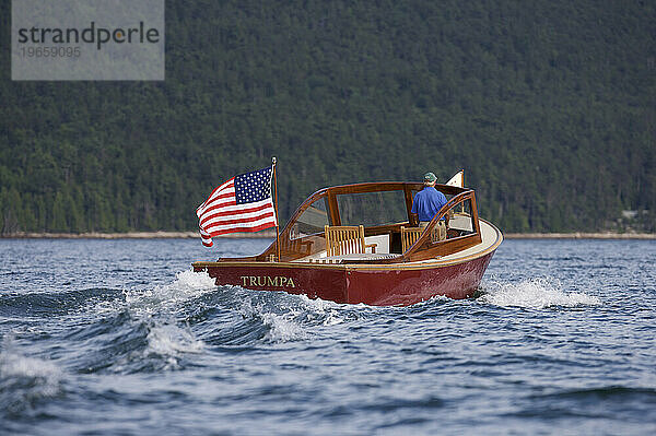 Älterer Mann fährt eine Motoryacht in Somes Sound  Maine.