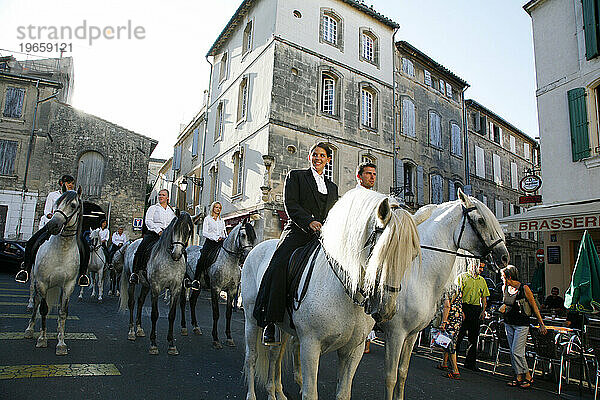 Menschen reiten Camargue-Pferde in Arles während der Feria du Riz  Reisfest  Provence  Frankreich.