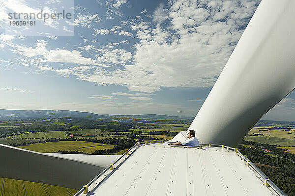 Ein Mann untersucht die Rotorblätter seiner Windkraftanlage in der Nähe von Chodov  Tschechien.