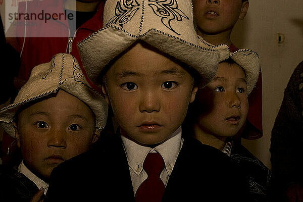 Kinder im Satellitenkindergarten tragen einen traditionellen Filzhut.