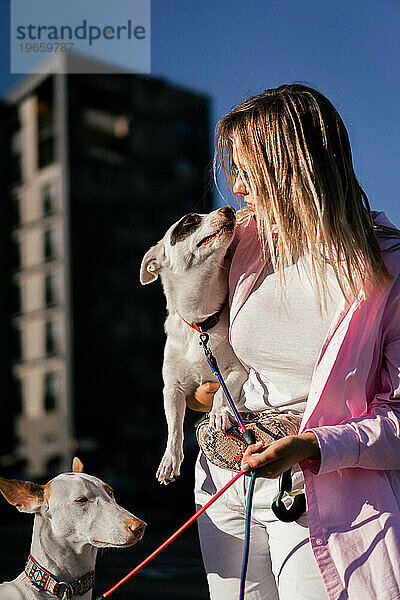 Junge Frau mit einem Hund im Arm.