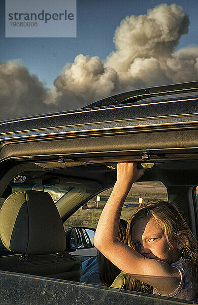 Ein junges Mädchen beobachtet den Schwarzwaldbrand am Horizont
