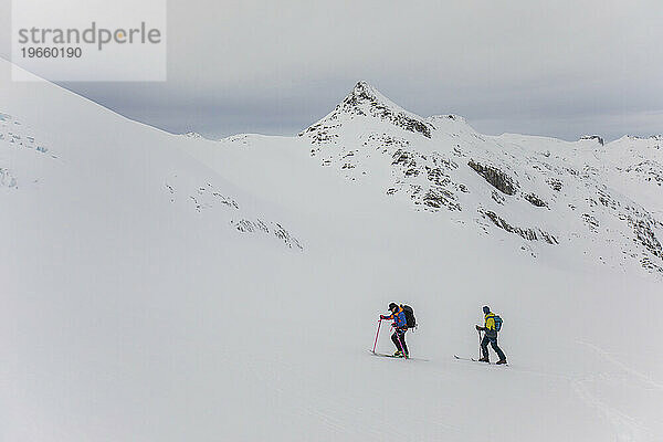 Seitenansicht von zwei Skifahrern beim Backcountry-Skifahren in B.C.