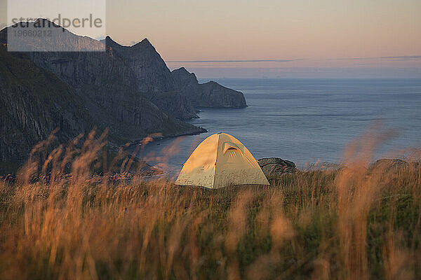 Zelt auf dem Küstenberg bei Sonnenuntergang  Moskenesoya  Lofoten  Norwegen