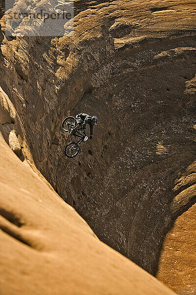 Mann fährt mit dem Mountainbike einen steilen Felsen hinunter in Moab  Utah.