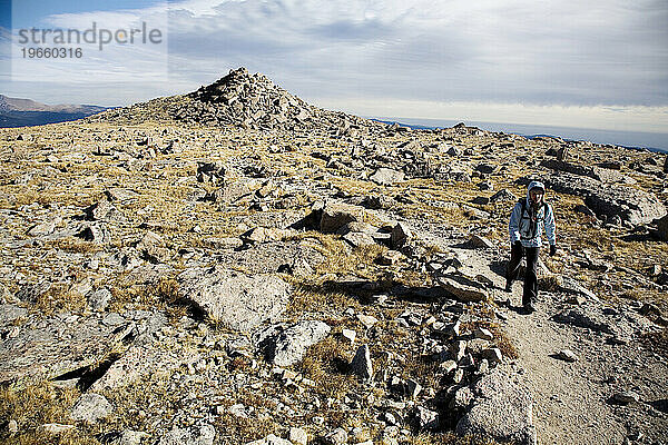 Ein junges Mädchen kämpft auf dem Weg zum Gipfel des Longs Peak im Rocky-Mountain-Nationalpark gegen Wind und Kälte.