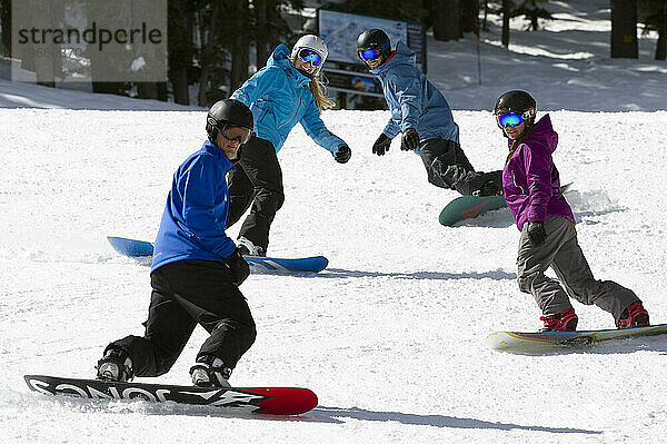 Eine Gruppe Snowboarder folgt ihrem Snowboardlehrer im Winter im Kirkwood Mountain Resort in Kirkwood  Kalifornien  eine präparierte Piste hinunter.