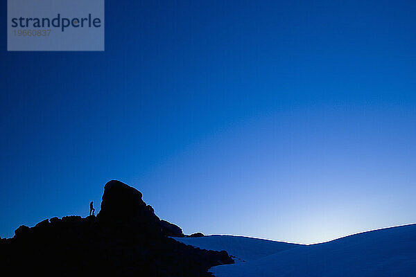 Ein Bergsteiger in der Silhouette in der Abenddämmerung  Mt. Baker  Washington State.