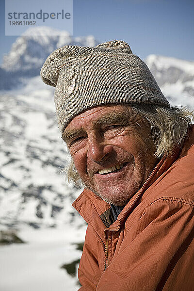 Ein Bergführer hält einen Moment in der Frühlingssonne der österreichischen Alpen  Salzkammergut  Österreich  inne.