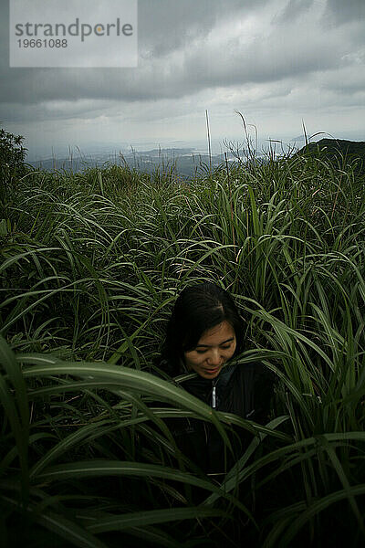 Eine Frau geht durch hohes Gras in der Nähe von Keelung  Taiwan.