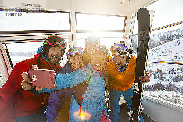 Eine Gruppe von Freunden macht ein Selfie in einer Gondel in einem Skigebiet.