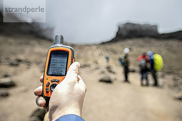 GPS-Gerät in der Hand eines Wanderers auf dem Weg zum Kilimandscharo  Tansania