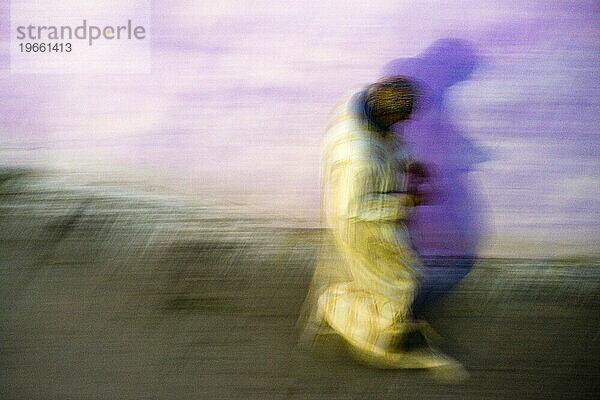 Eine abstrakte Ansicht eines Mannes in einer Djellaba  der in Tanger  Marokko  spaziert.