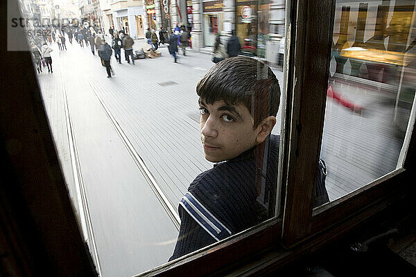 Junger Mann stiehlt eine Mitfahrgelegenheit auf dem Rücksitz einer Straßenbahn in Istanbul  Türkei.