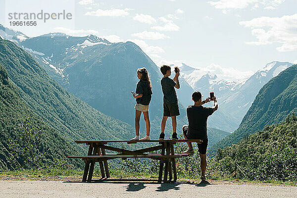 Vater und seine Kinder machen ein Foto von der Aussicht in Norwegen