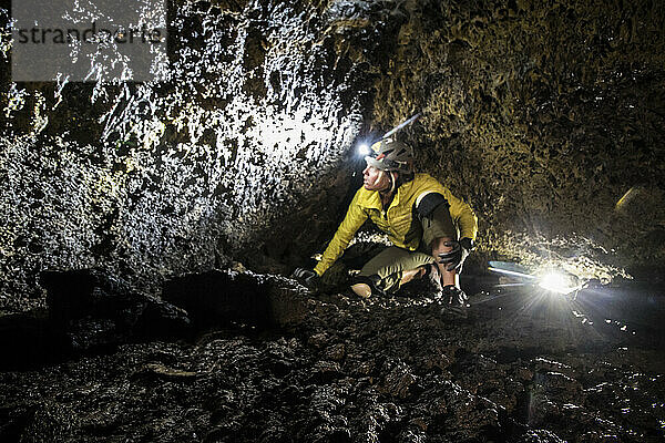 Eine junge Frau erkundet eine Vulkanhöhle im Lava Beds National Monument